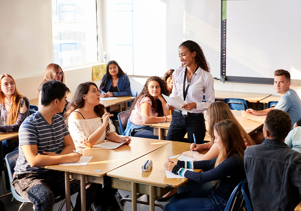High school teacher in a classroom with students.